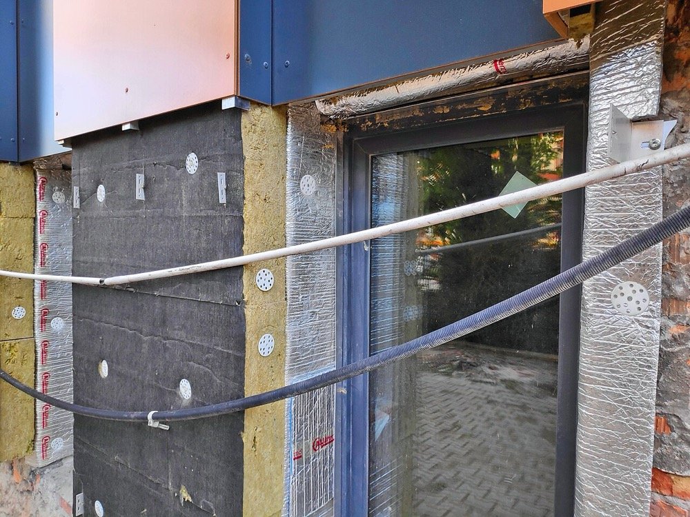Chantier de rénovation énergétique avec isolation thermique par l'extérieur en laine minérale sur un bâtiment